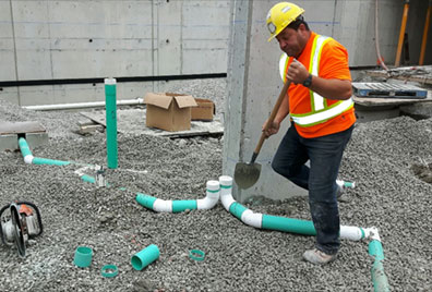 Worker Setting Underground Drain Pipes